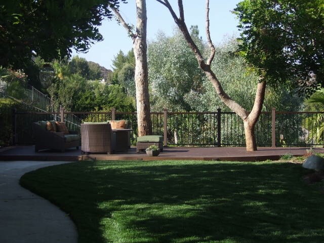 This is an example of a large contemporary full sun backyard landscaping in Los Angeles with decking for summer.