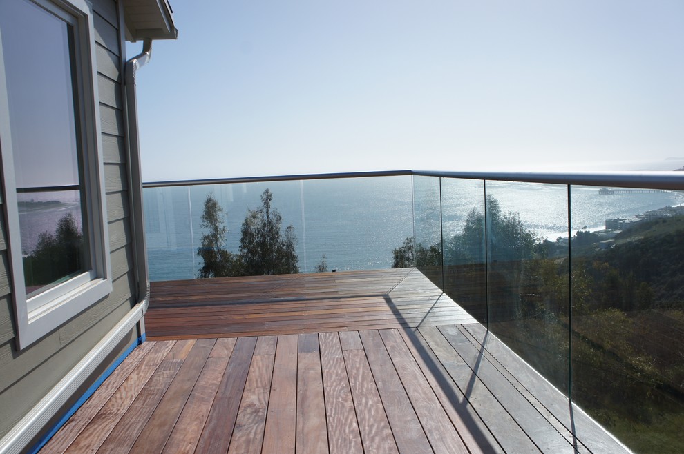 Large contemporary back full sun garden for summer in Los Angeles with an outdoor sport court, a retaining wall and decking.