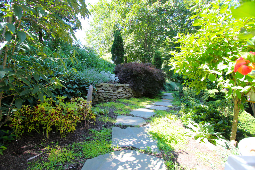 Ejemplo de jardín tradicional en patio trasero con adoquines de piedra natural