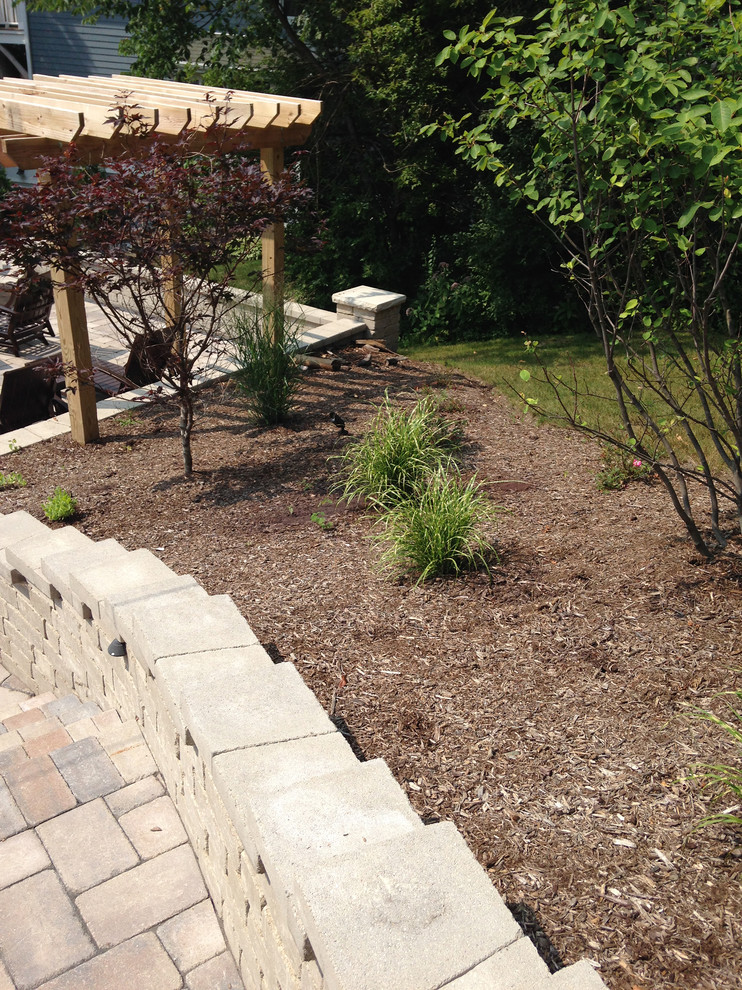 Inspiration for a large contemporary sloped partial sun garden in Milwaukee with a pathway and brick paving.