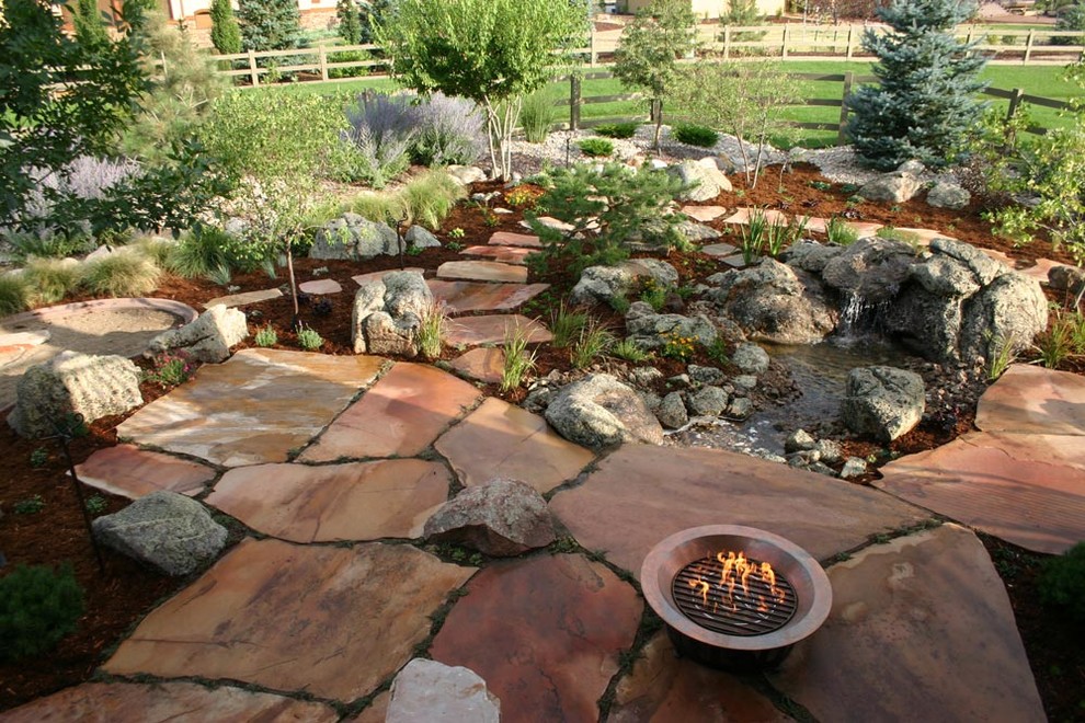 Photo of a large classic back partial sun garden in Other with a water feature and mulch.