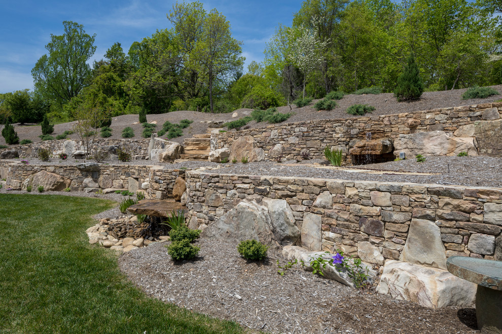 Inspiration for a huge traditional drought-tolerant and partial sun backyard stone retaining wall landscape in Other for summer.