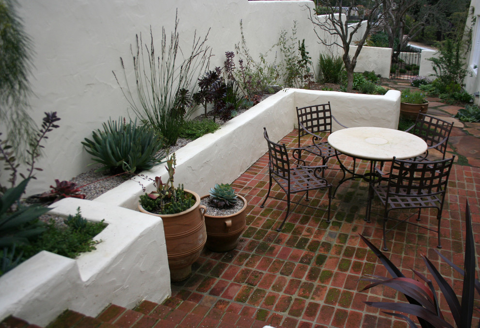 Diseño de jardín mediterráneo de tamaño medio en patio trasero con adoquines de ladrillo
