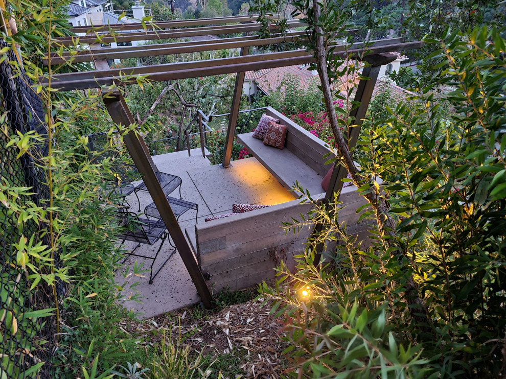 Immagine di un giardino minimalista esposto a mezz'ombra di medie dimensioni e dietro casa in inverno con pavimentazioni in cemento e recinzione in metallo