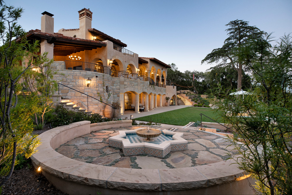 Mediterraner Garten hinter dem Haus mit Wasserspiel und Natursteinplatten in Santa Barbara