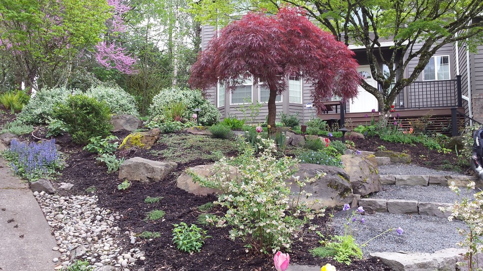 Foto di un piccolo giardino stile rurale esposto a mezz'ombra davanti casa in primavera con un ingresso o sentiero e ghiaia
