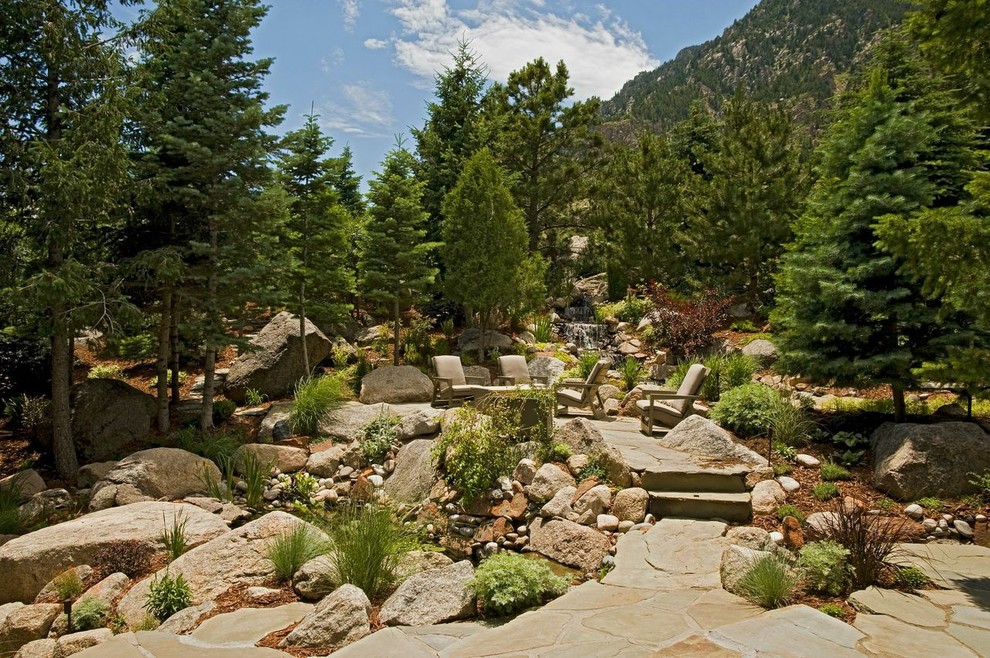 Exemple d'un grand jardin arrière chic avec des pavés en pierre naturelle, un point d'eau et une exposition partiellement ombragée.
