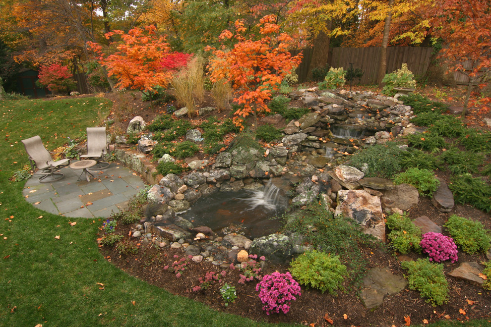 На фото: осенний садовый фонтан среднего размера на склоне в современном стиле с полуденной тенью и покрытием из каменной брусчатки