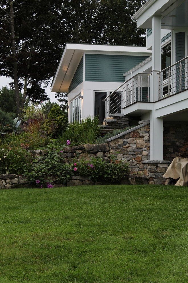 Medium sized contemporary front formal full sun garden in Boston with a retaining wall and natural stone paving.