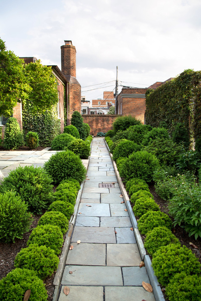 Modelo de jardín clásico de tamaño medio en patio trasero con jardín francés, exposición total al sol y adoquines de ladrillo