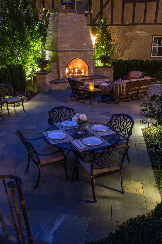 Imagen de patio clásico en patio trasero con adoquines de piedra natural
