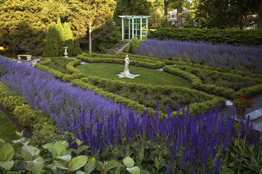 Ejemplo de jardín clásico grande en patio trasero con jardín francés y parterre de flores