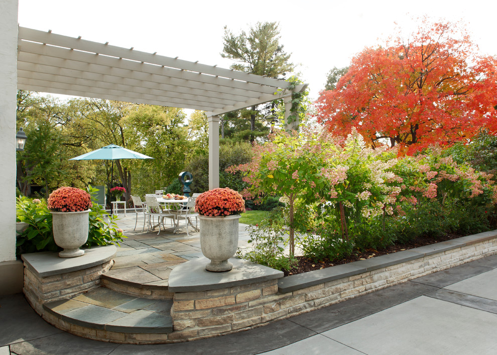 Immagine di un grande giardino formale classico esposto in pieno sole dietro casa con pavimentazioni in pietra naturale