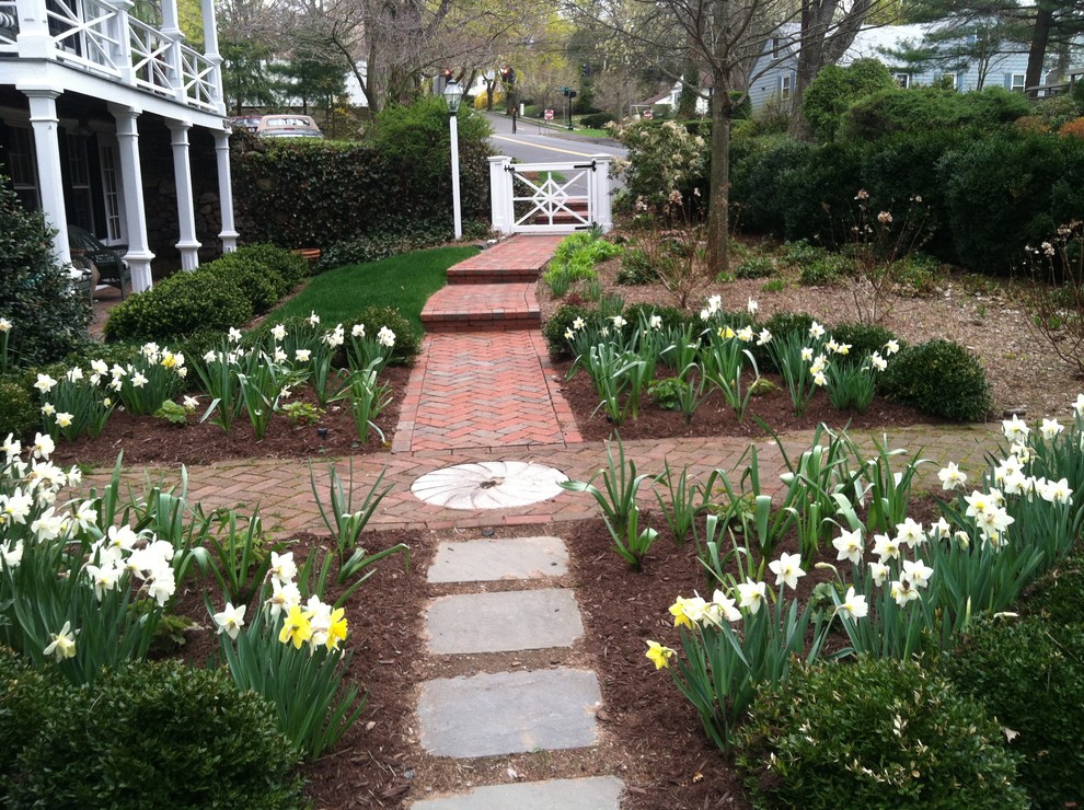 This is an example of a small farmhouse front formal partial sun garden in New York with brick paving and a garden path.