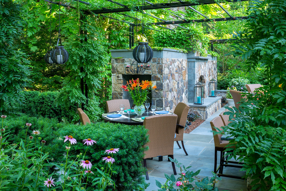 Modelo de jardín clásico en patio trasero con jardín francés, brasero y adoquines de piedra natural