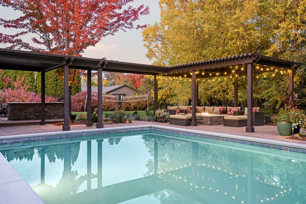 Photo of a large contemporary back partial sun garden for autumn in Boise with a fire feature and brick paving.