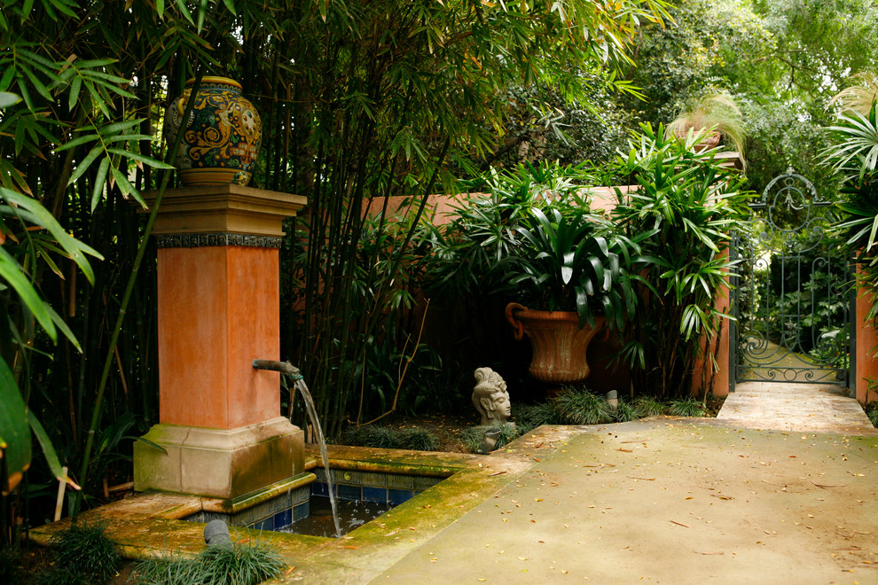 Foto på en medelhavsstil trädgård, med en fontän