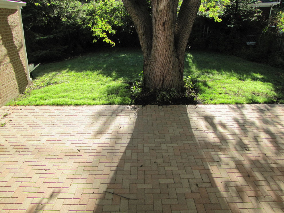 Imagen de acceso privado clásico de tamaño medio en primavera en patio trasero con exposición reducida al sol y adoquines de ladrillo