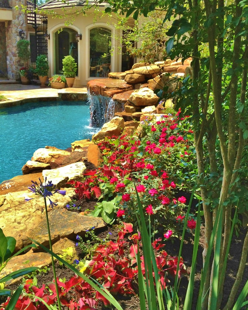Foto de jardín mediterráneo de tamaño medio en verano en patio trasero con jardín francés, exposición parcial al sol y adoquines de piedra natural