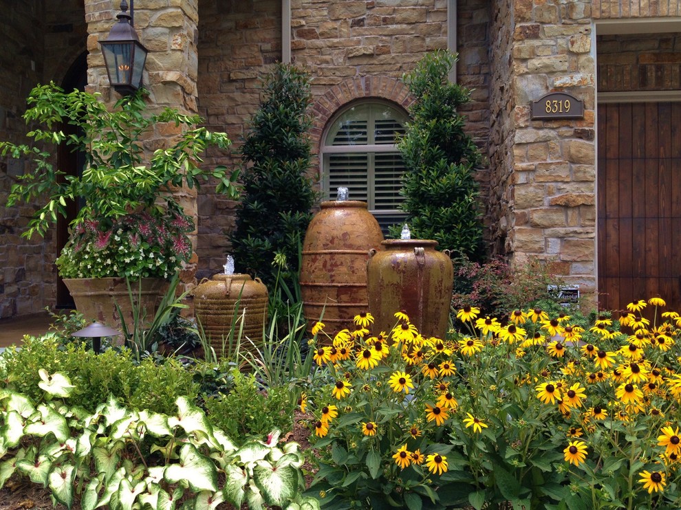 This is an example of a large traditional full sun front yard landscaping in Houston for summer.