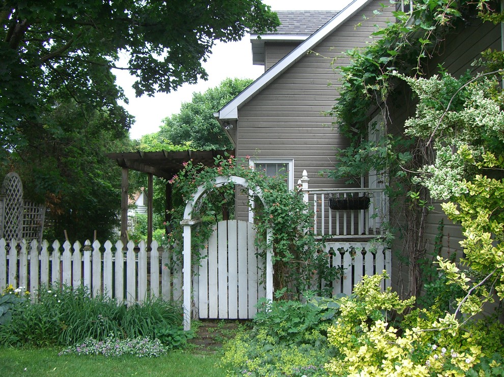 This is an example of a large classic back fully shaded garden fence for summer in Toronto with natural stone paving.