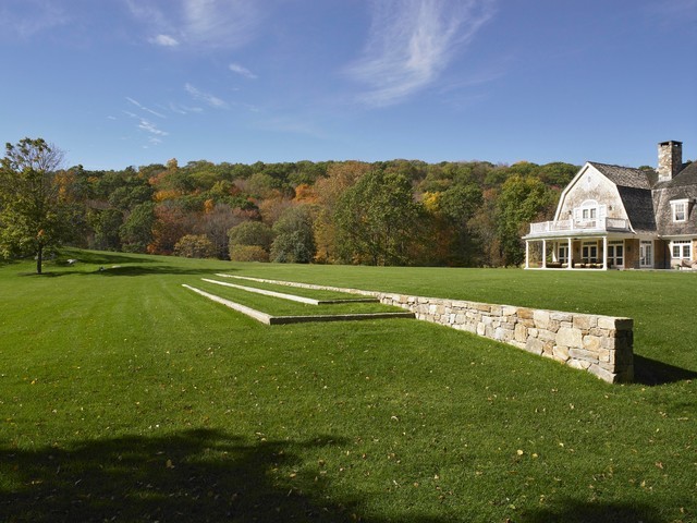 Photo of a huge traditional full sun hillside stone retaining wall landscape in New York for fall.