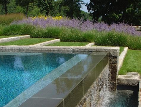 This is an example of a huge traditional full sun side yard stone water fountain landscape in Other for summer.