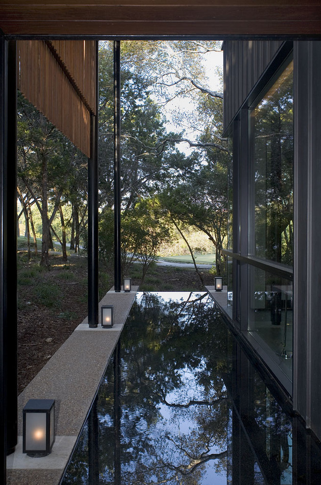 Photo of a contemporary garden in Austin with a water feature.