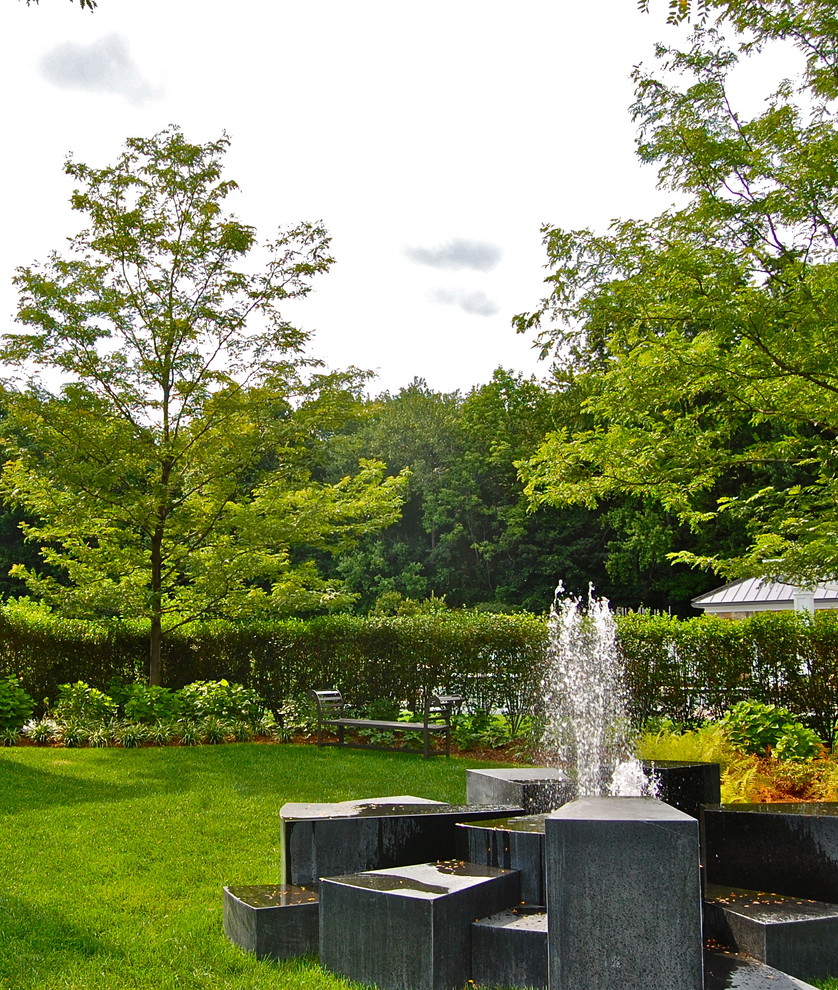 Diseño de jardín clásico en patio trasero con fuente