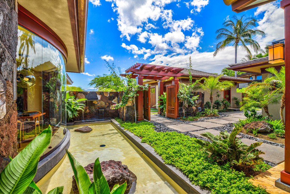 Immagine di un giardino tropicale di medie dimensioni e in cortile con fontane