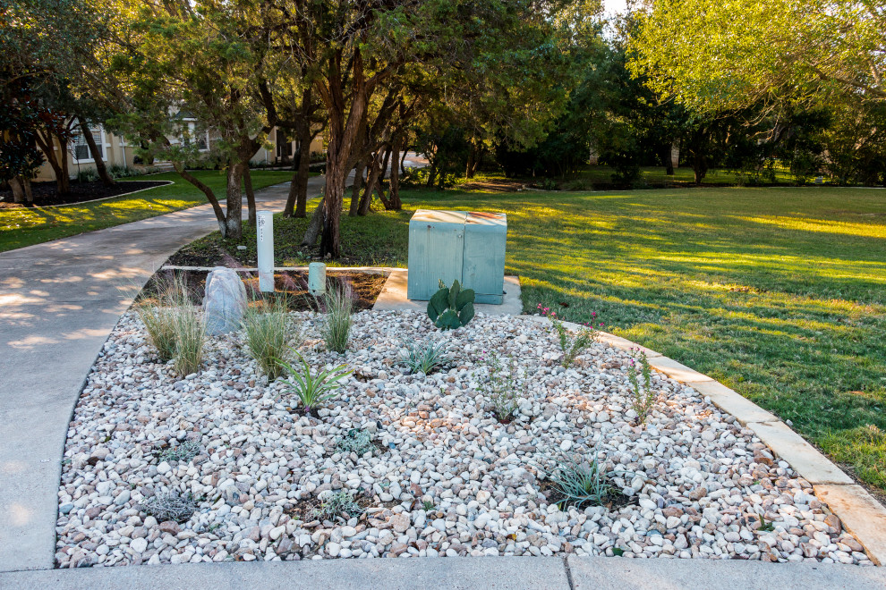 Medium sized contemporary front xeriscape partial sun garden for summer in Austin with a desert look and decorative stones.