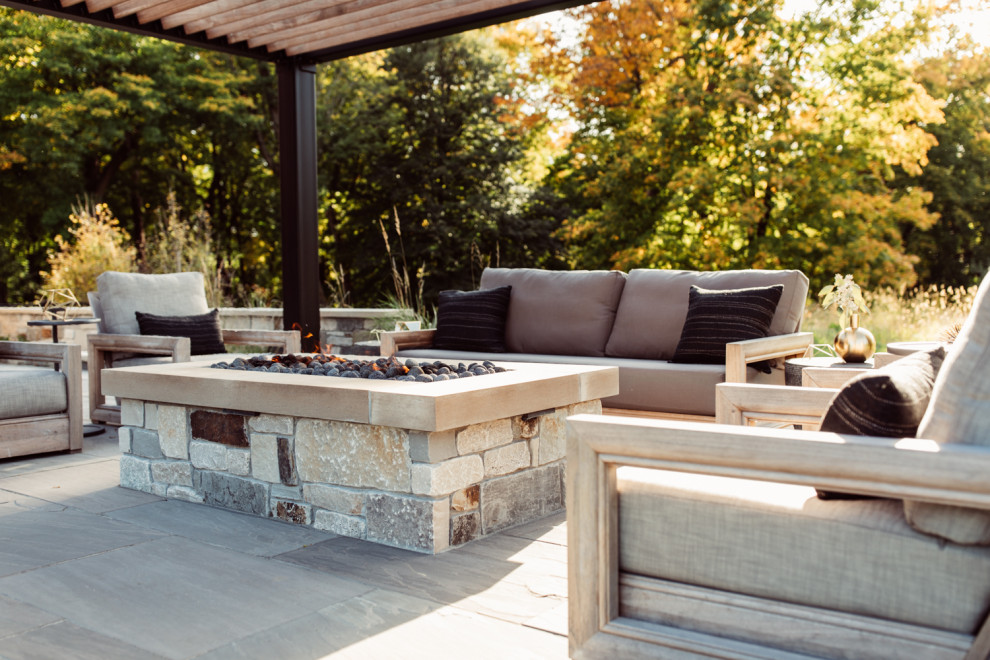 Esempio di un patio o portico minimalista dietro casa con un focolare e pavimentazioni in pietra naturale