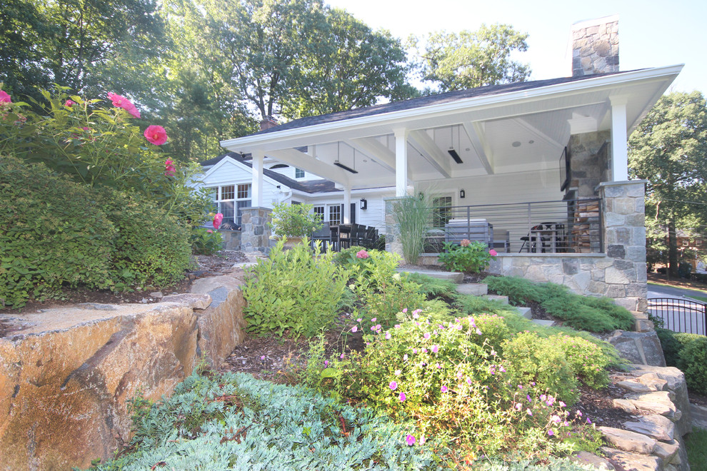 На фото: большой летний регулярный сад на заднем дворе в стиле неоклассика (современная классика) с покрытием из каменной брусчатки, подпорной стенкой и полуденной тенью