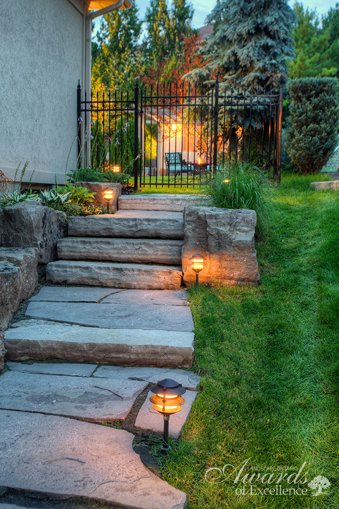 Design ideas for a traditional side yard stone garden path in Toronto.