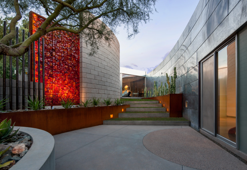 Пример оригинального дизайна: огромный солнечный, весенний регулярный сад на внутреннем дворе в стиле модернизм с подпорной стенкой, хорошей освещенностью и мощением тротуарной плиткой