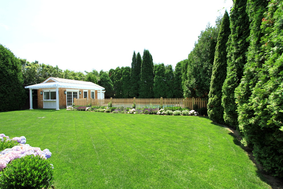 На фото: большой участок и сад на заднем дворе в классическом стиле с забором