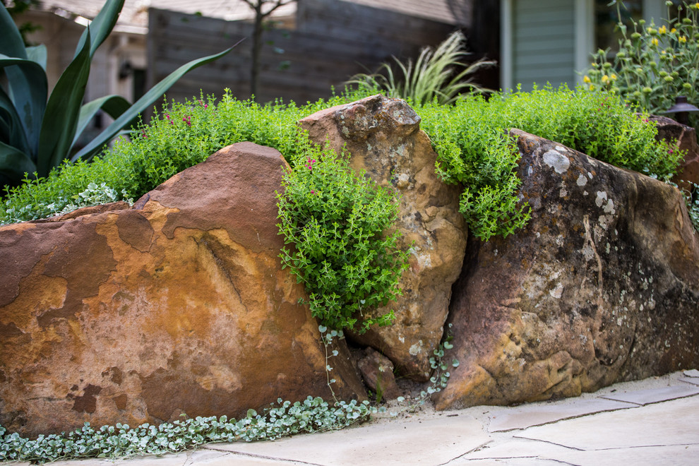 Medium sized modern front garden in Austin with a retaining wall.