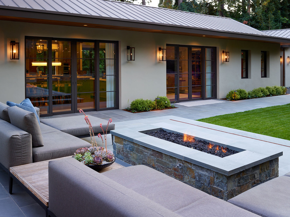 Diseño de jardín moderno grande en patio delantero con brasero, exposición total al sol y adoquines de piedra natural