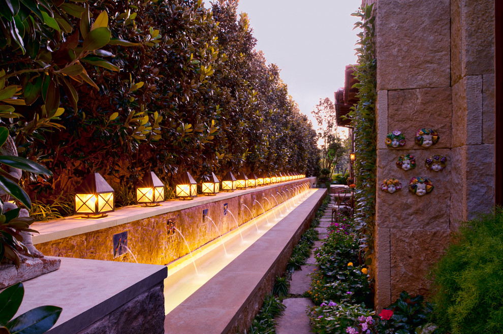 This is an example of a mediterranean garden in Dallas with a water feature.