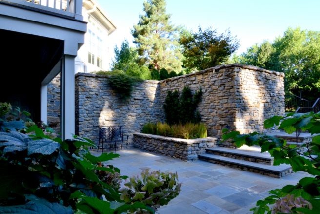 Imagen de jardín extra grande en patio lateral con muro de contención, exposición parcial al sol y adoquines de piedra natural