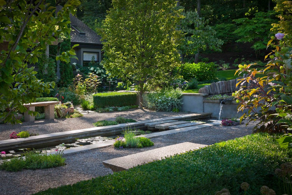 Immagine di un giardino design esposto in pieno sole di medie dimensioni e davanti casa con fontane e ghiaia