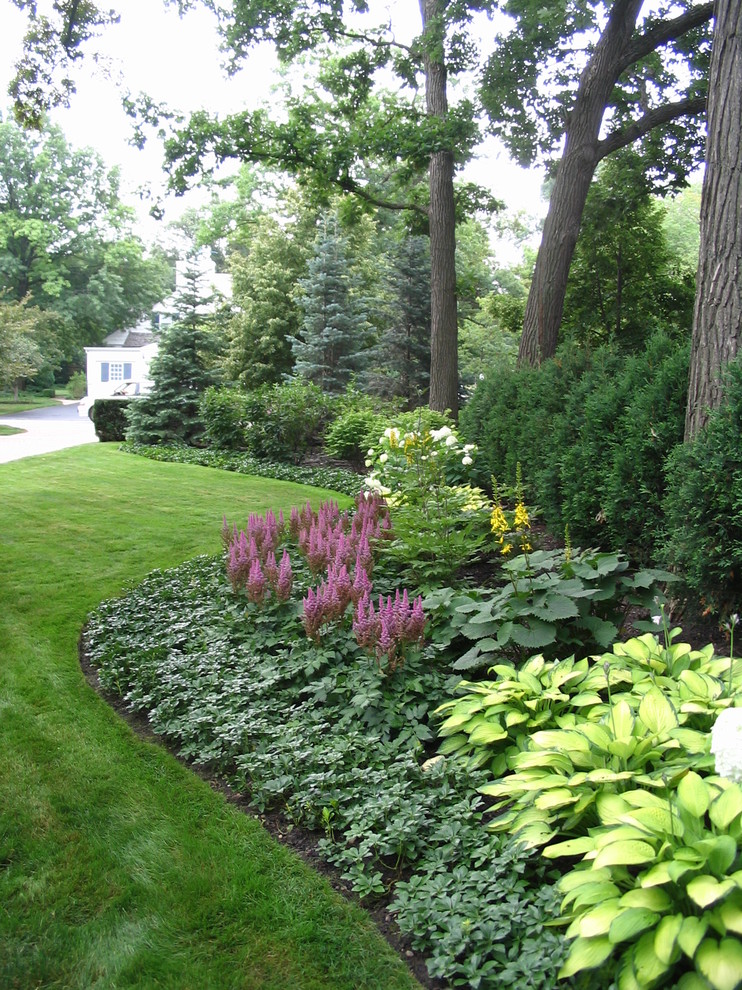 На фото: летний регулярный сад на переднем дворе в классическом стиле с полуденной тенью