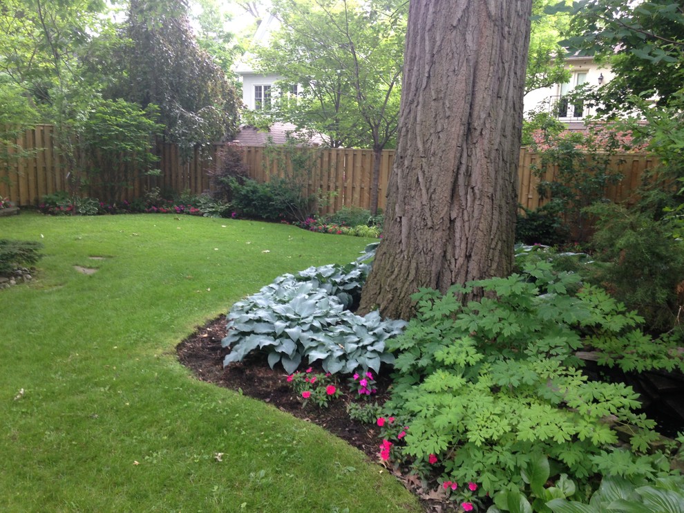Exemple d'un jardin arrière chic de taille moyenne avec une exposition partiellement ombragée et un paillis.