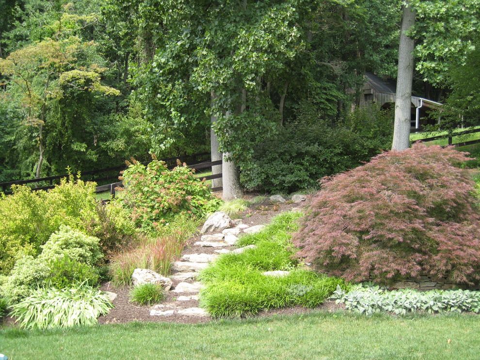 Imagen de jardín tradicional de tamaño medio en ladera con adoquines de piedra natural