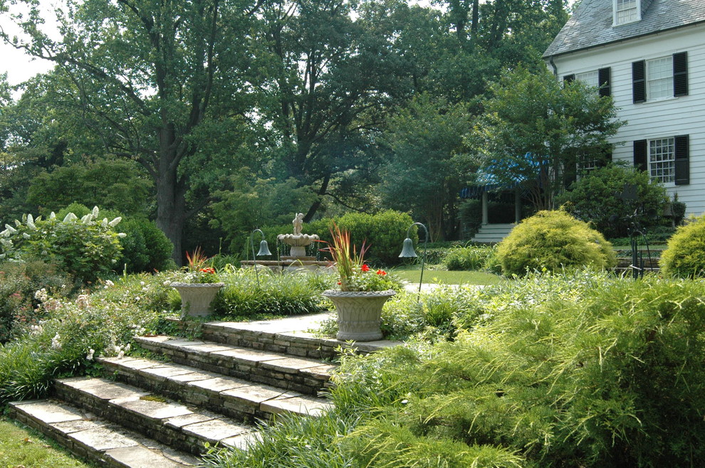 Ejemplo de jardín tradicional grande en patio trasero con exposición parcial al sol y adoquines de piedra natural