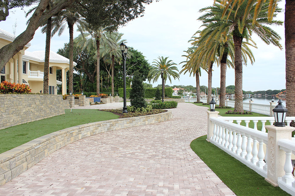 Design ideas for a large contemporary backyard concrete paver retaining wall landscape in Miami.