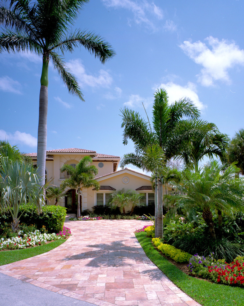 Großer Vorgarten im Sommer mit direkter Sonneneinstrahlung, Natursteinplatten und Auffahrt in Miami