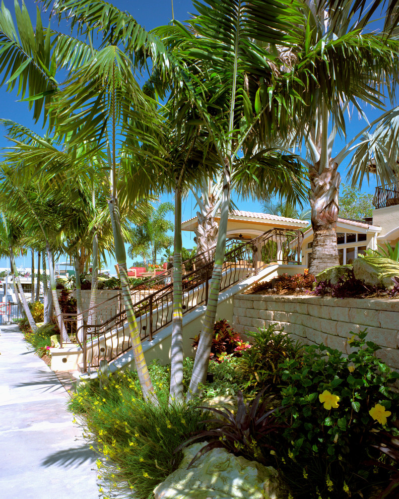 Idee per un grande giardino formale tropicale esposto in pieno sole dietro casa in estate con pavimentazioni in pietra naturale