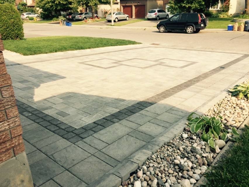 Photo of a modern front driveway garden in Ottawa with concrete paving and a raised bed.