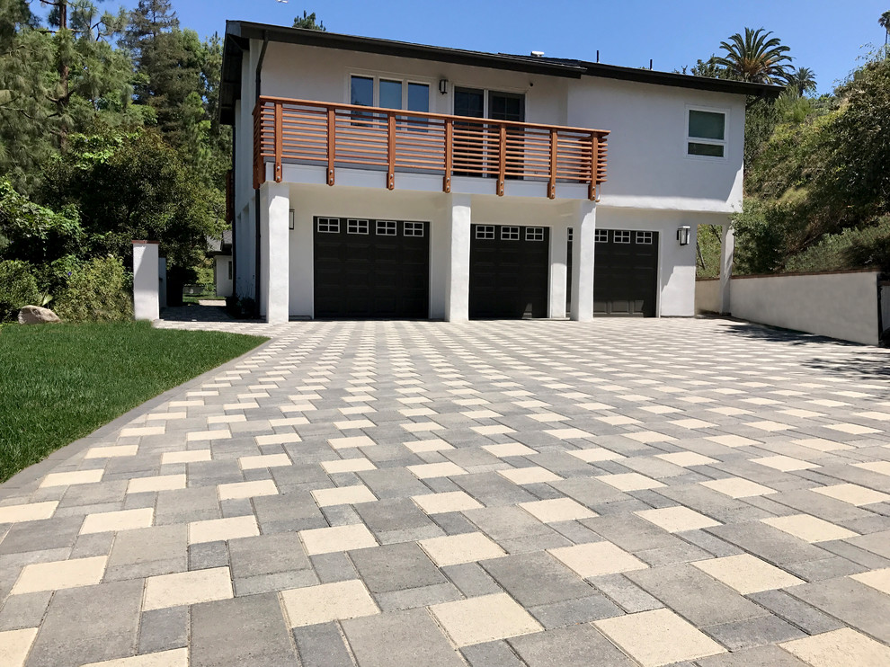This is an example of a modern front driveway garden in Orange County with concrete paving.